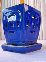 Planter side view showing blue glaze, cut-outs, and saucer