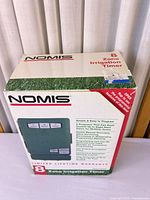 Front of sealed NOMIS 8-Zone Irrigation Timer retail box