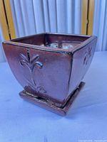 overall view of square reddish-brown planter with saucer