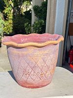 Front view of terracotta planter showing scalloped rim and diamond pattern