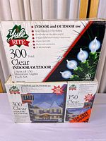 Front view of both boxed light sets showing brand, bulb count and indoor/outdoor designation