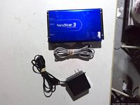 Blue Vantec NexStar 3 enclosure with power adapter and USB cable on table