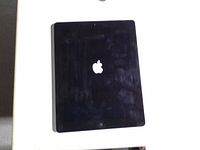 Front view of powered-on iPad displaying Apple logo