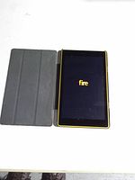 Front view of powered-on Amazon Fire tablet with attached black tri-fold cover