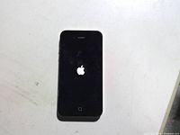 Front of powered-on iPhone displaying Apple logo during boot