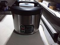 Front view of stainless Aroma cooker showing brand logo and control panel