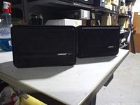 Front view of both Bose 151 speakers on table