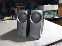 front view showing both speakers, grille design, volume knob