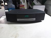 Front view showing Bose Wave Music System powered on at 12:00 display