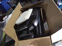 Box with multiple keyboards visible, white keyboard on top