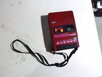 Front view showing red face, tape controls, ALC label and wrist strap