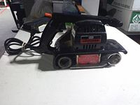 Left side view of entire sander showing shape, handle, belt area and cord