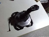 Top view of Logitech Extreme 3D Pro joystick showing handle, buttons, base and damaged cable end