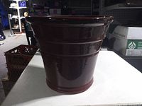 Side view showing burgundy glazed exterior and tapered shape