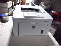 Front view of HP LaserJet Pro M203dw printer showing power indicator lit