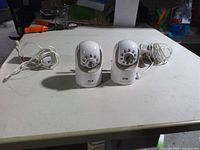 Front view of two Infant Optics cameras with power cables