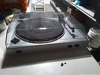 Front view showing platter, tonearm, dust cover and controls