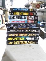 Nine paperback novels stacked showing spines