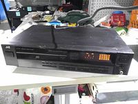 Front view showing JVC branding, controls and display illuminated