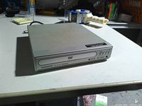 Front view of Magnavox silver DVD player showing disc tray and control buttons