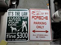 Front view of both metal signs showing graphics and text