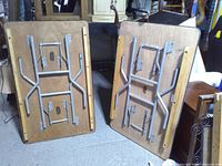 Two folding tables underside showing steel leg mechanisms