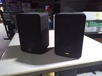 Front view of both black RCA bookshelf speakers