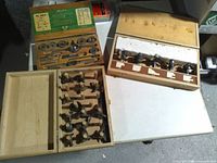Overview of three open wooden tool boxes showing tap and die set, router bits set, stacked cutter set