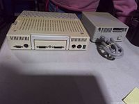 Rear ports of Apple IIc beside external drive showing connectors and overall wear