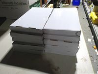 Stack of ten sealed white keyboard boxes