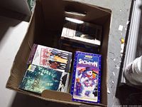 Open top view of bankers box showing several VHS tapes including The Snowman, Riverdance and Friends