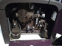 Projector mechanism inside case showing motor, film path and controls