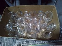 Overhead view of 16 clear wine glasses packed in box