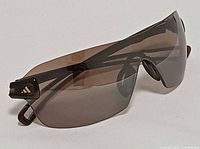 Three-quarter front view of sunglasses showing lens and right temple
