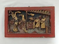 Front view of carved gilt panel showing figures and architecture
