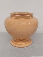 Front view of peach-glazed Cowan Pottery vase