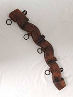 Front view of full wooden coat rack showing four hooks and rings