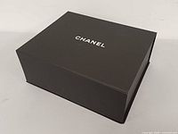Top view of black Chanel box with white logo