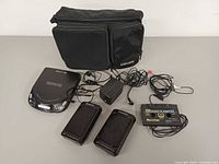 All items laid out: Kenwood CD player, Panasonic speakers, AC adapter, Recoton cassette adapter, earbuds, Case Logic bag