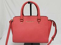Front view of pink Michael Kors Selma satchel showing logo, handles, shape and color