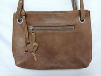 Front view showing tan leather, front zip pocket, texture
