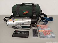 Complete lot showing camcorder, bag, remote, two batteries and two sealed tapes