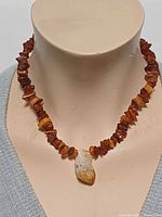 Necklace on display bust showing amber chips and citrine pendant