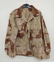 Front view of desert camouflage BDU jacket on hanger