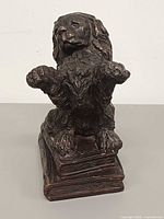 Front view of bronze spaniel bookend on stacked books