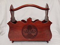 Front view showing carved Shou medallion, scalloped edges, curved handle