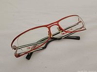 Oblique view showing red front frame and black temples