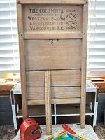Full view of The Columbia washboard with ruler, clothespins and red dispenser visible