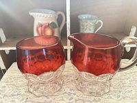 Ruby flashed hobnail creamer and sugar, clear bases visible