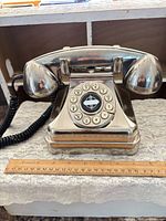Front view of Crosley CR62 chrome telephone with ruler for scale
